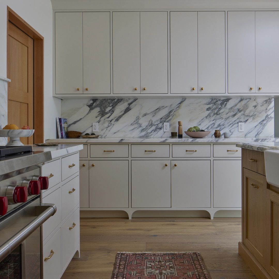 a kitchen with white cabinets and a rug on the floor