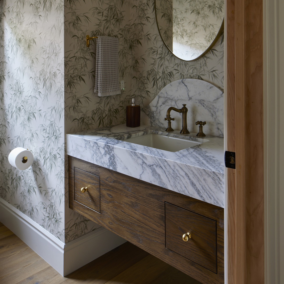 a bathroom with a marble counter top and wooden cabinets