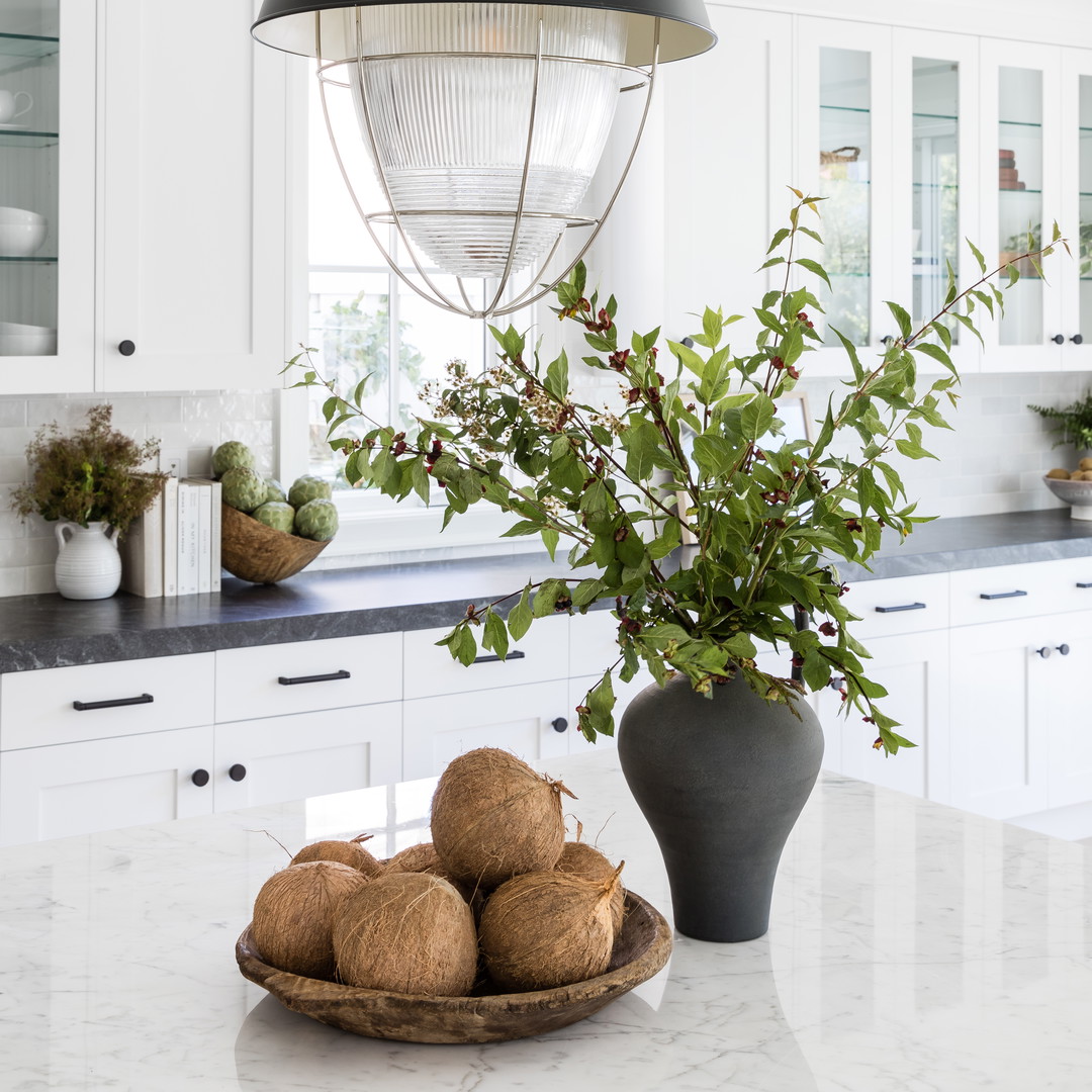 a bowl of fruit sitting on top of a kitchen counter