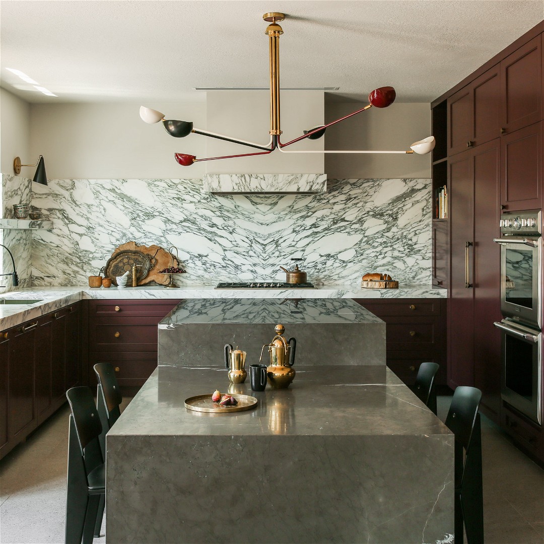 a kitchen with marble counter tops and wooden cabinets