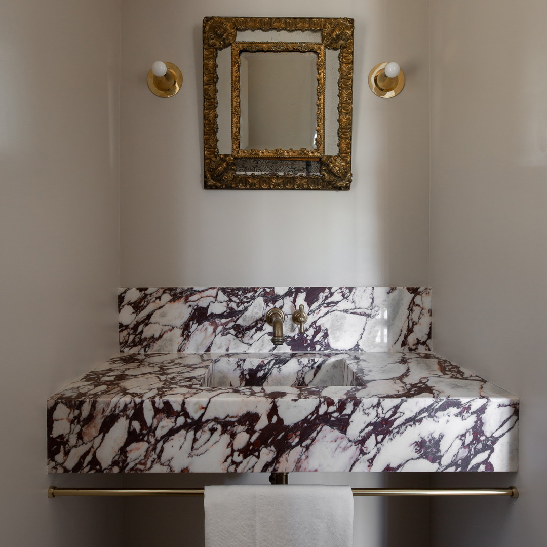 a bathroom with a marble sink and mirror