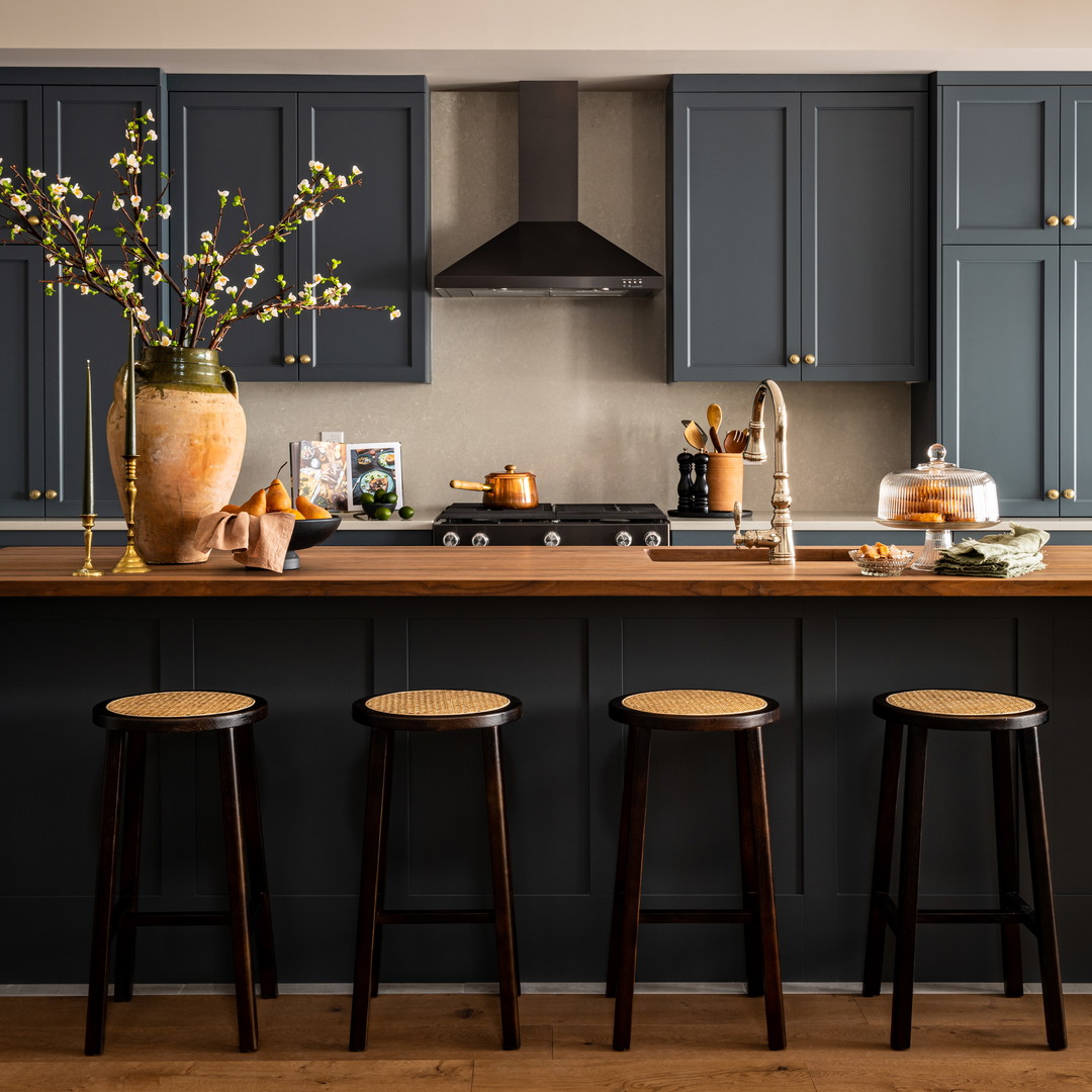 a kitchen with blue cabinets and stools