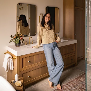 a woman standing in front of a bathroom sink