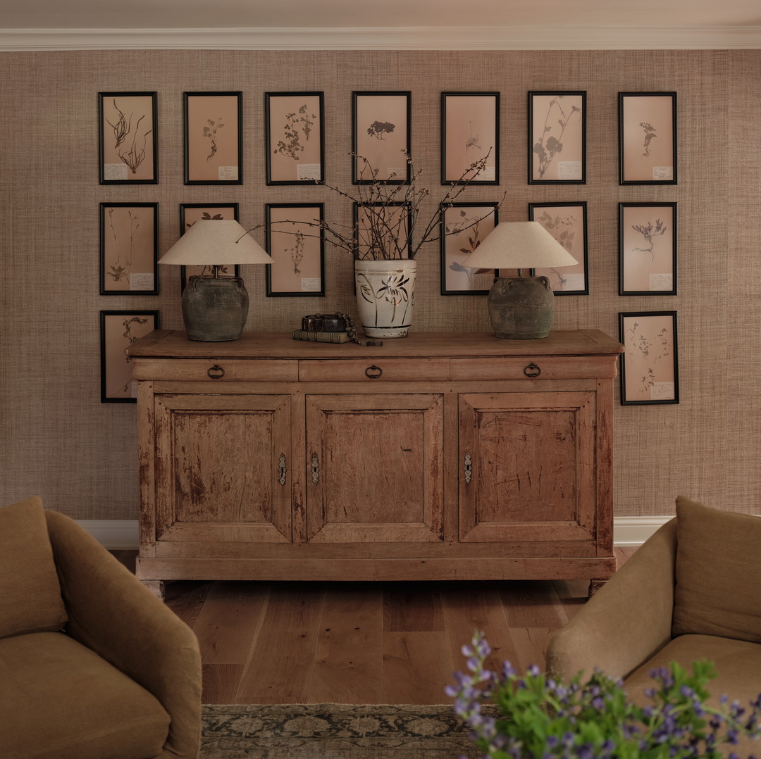a living room filled with furniture and pictures on the wall