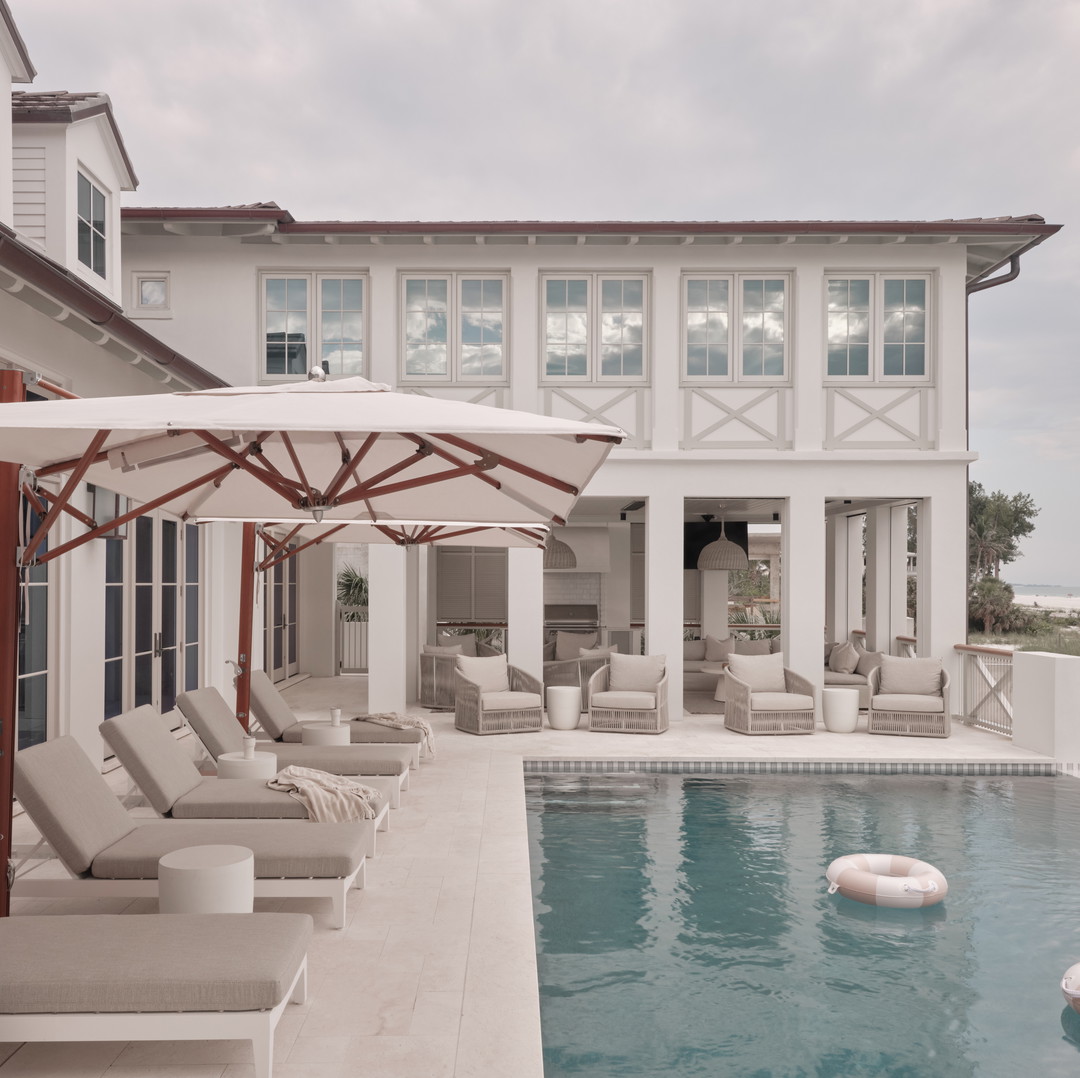 a house with a swimming pool and lounge chairs