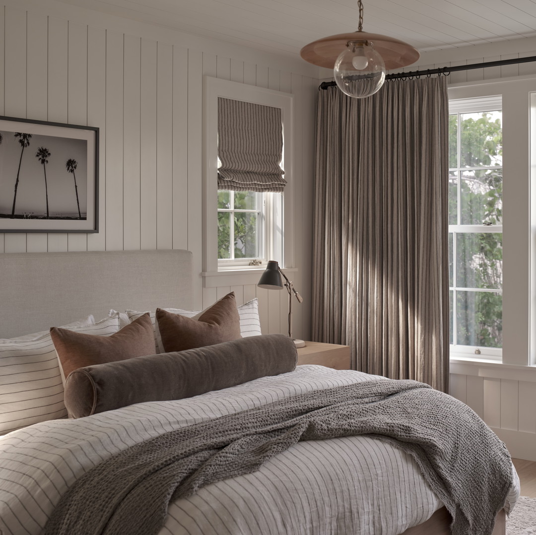 a bedroom with a large bed and a chair
