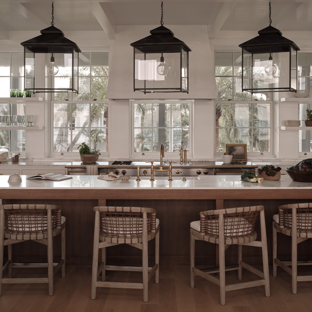 a kitchen with a large center island with chairs around it