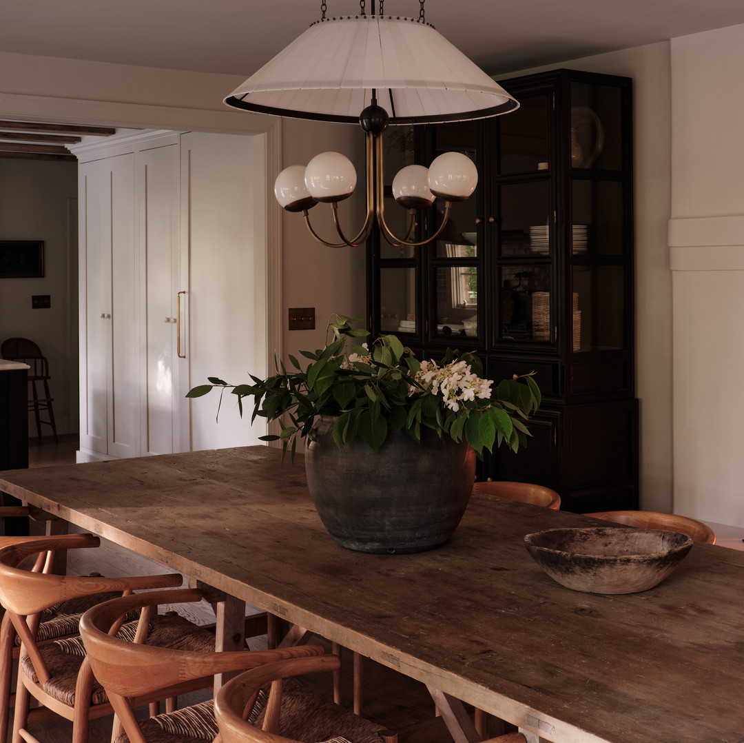 a dining room table with a bowl of flowers on it