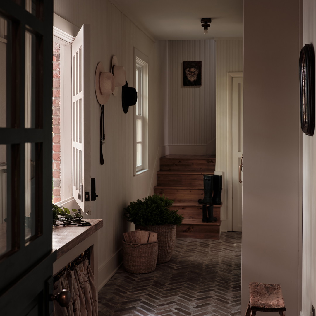 a hallway with a brick floor and wooden steps