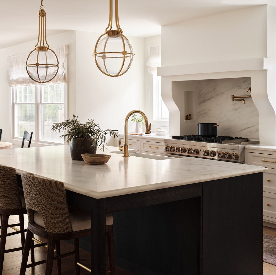 a large kitchen with a center island with chairs