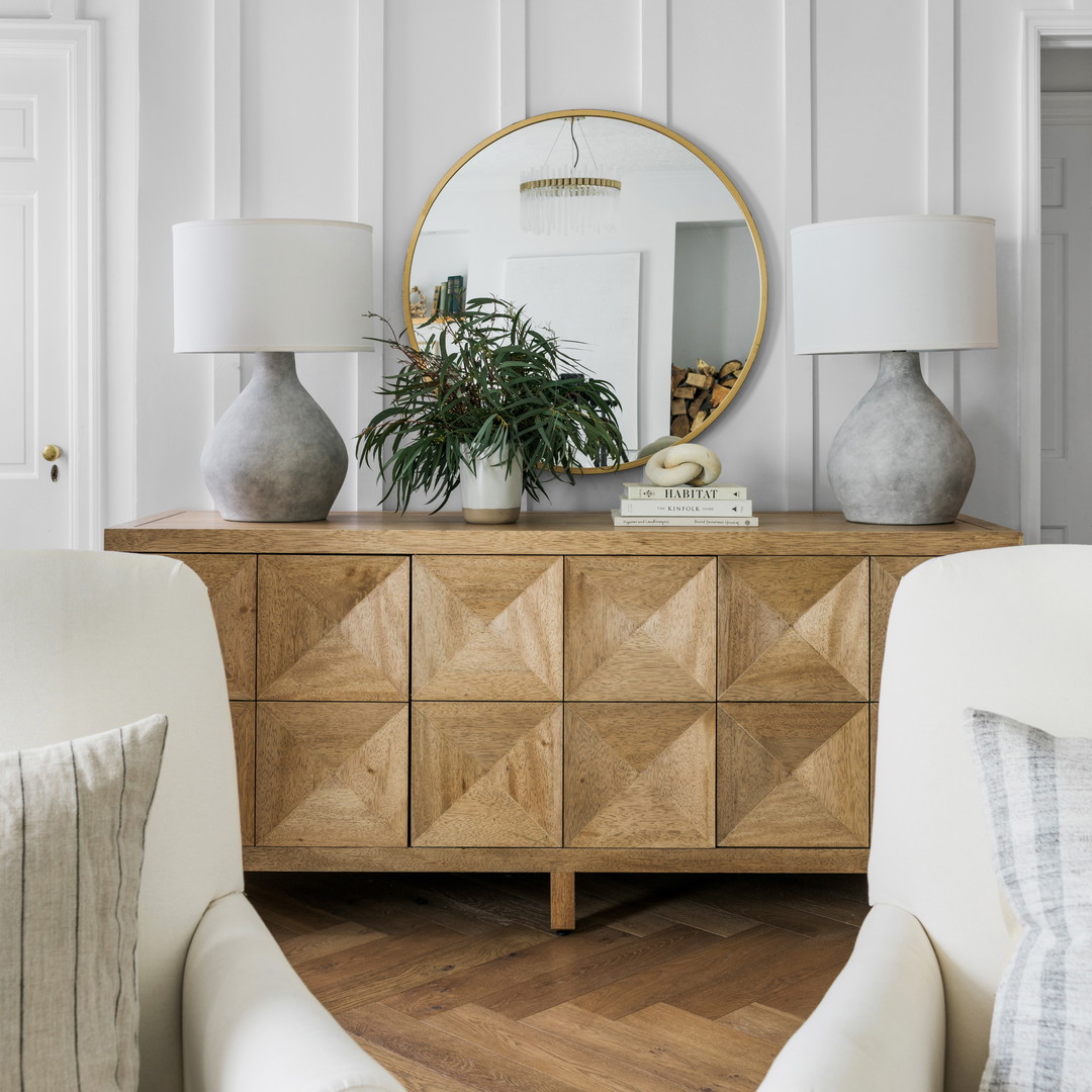 a living room with two chairs and a dresser