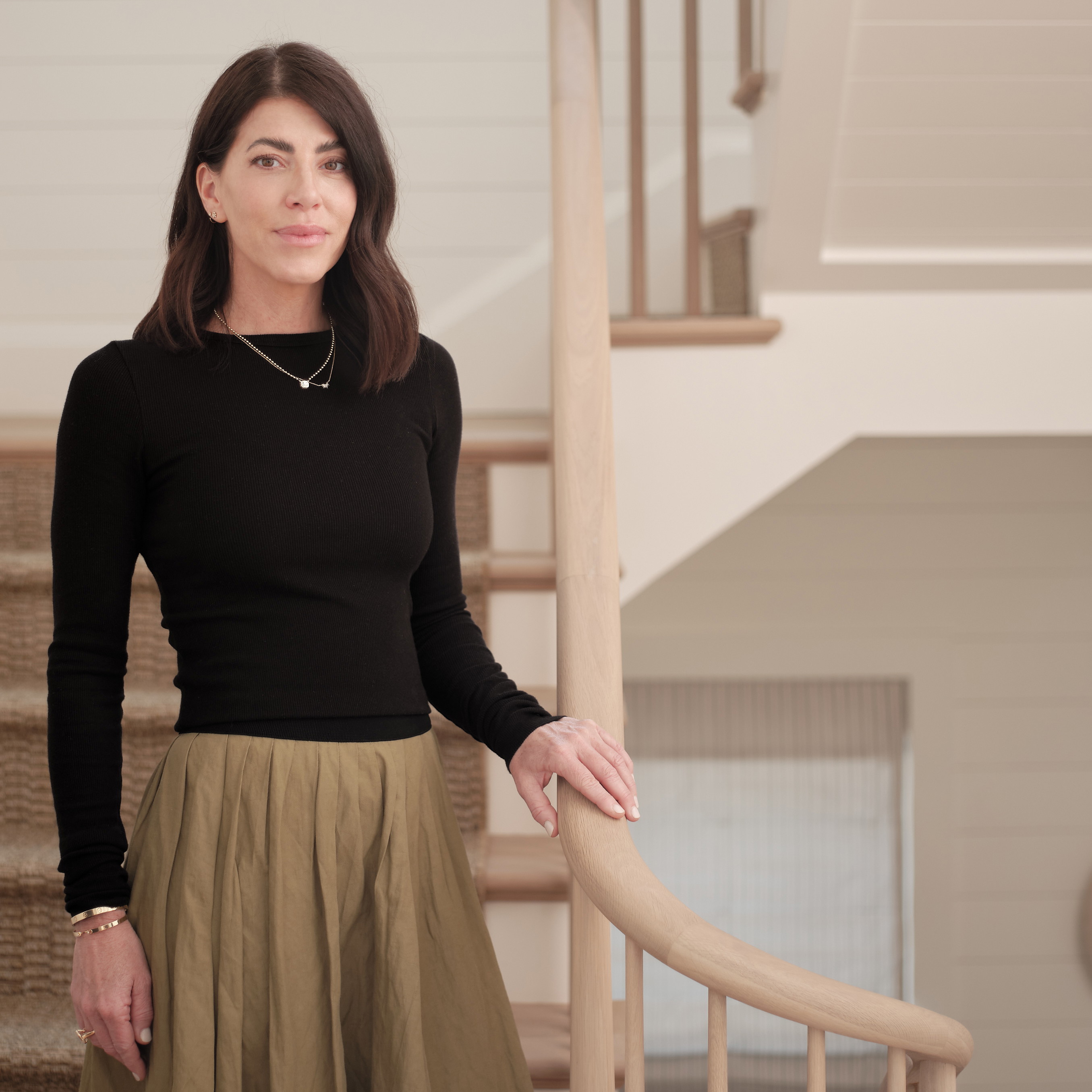 a woman in a black top and a tan skirt