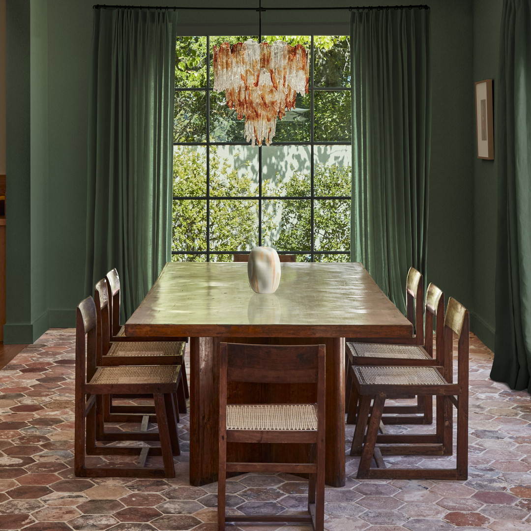 a dining room with a large wooden table surrounded by chairs