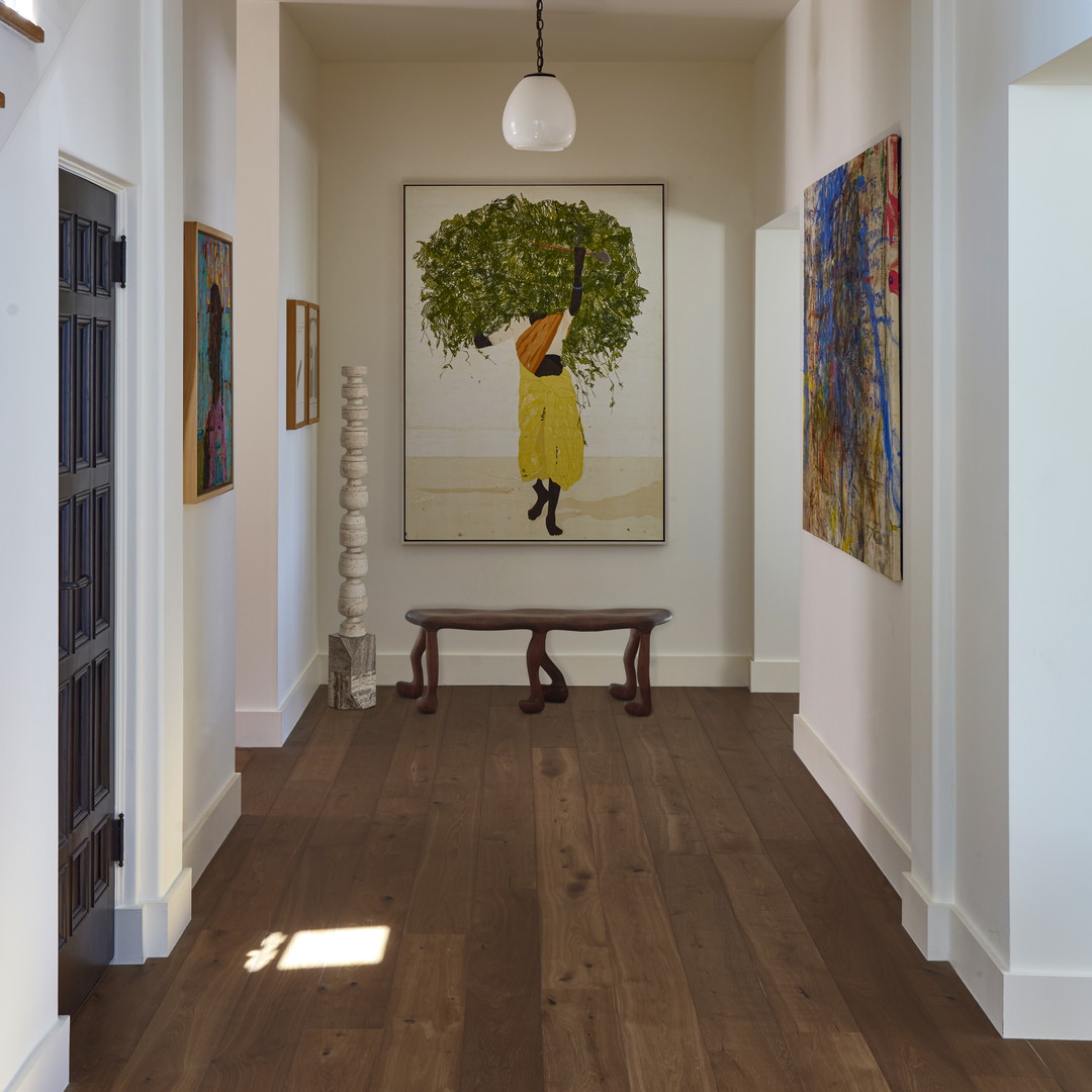 a hallway with a bench and a painting on the wall