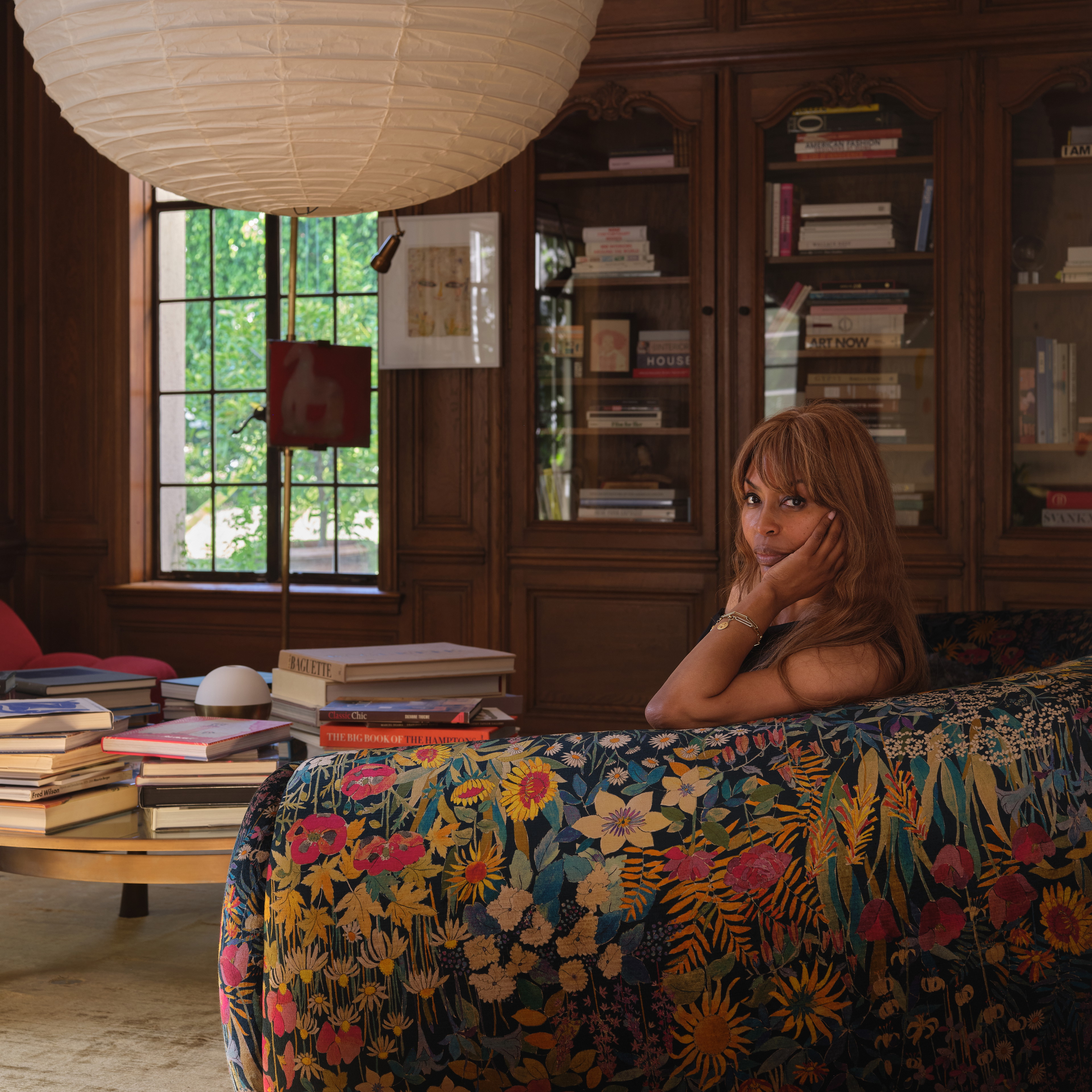 a woman sitting on a couch in a library