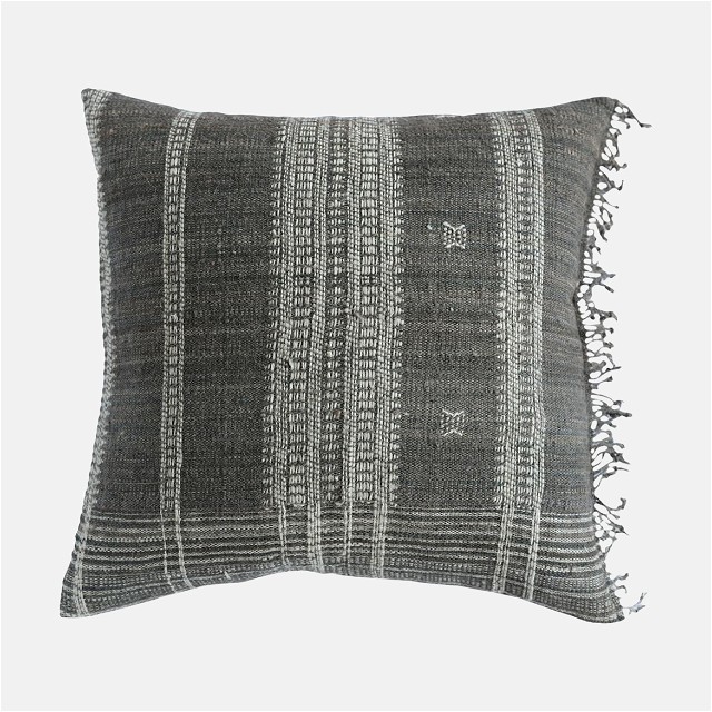 a black and white striped pillow with fringes