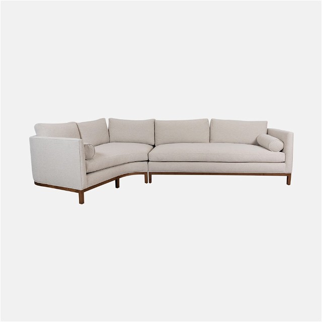 a white sectional couch with a wooden frame
