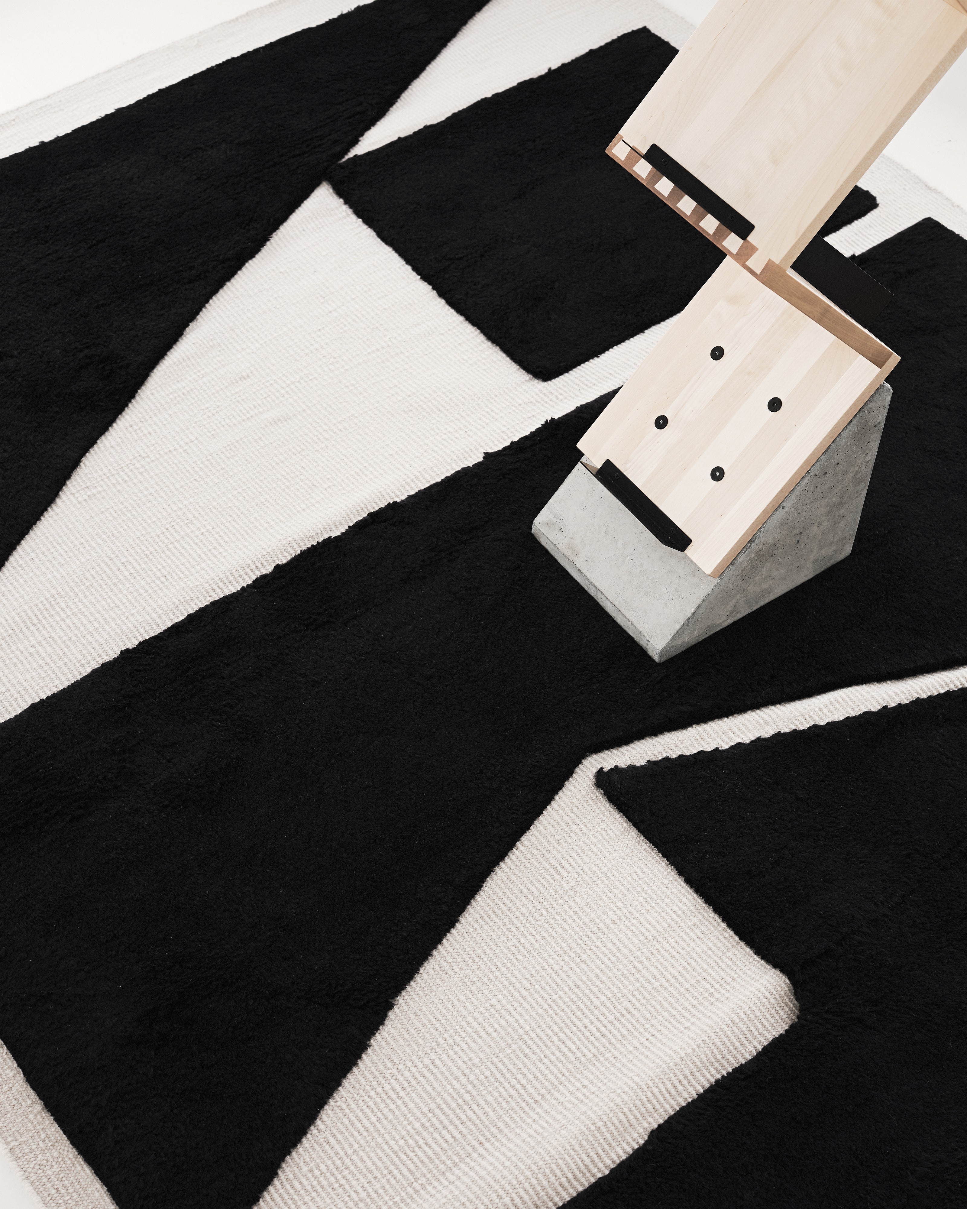 a black and white rug with a wooden object on top of it