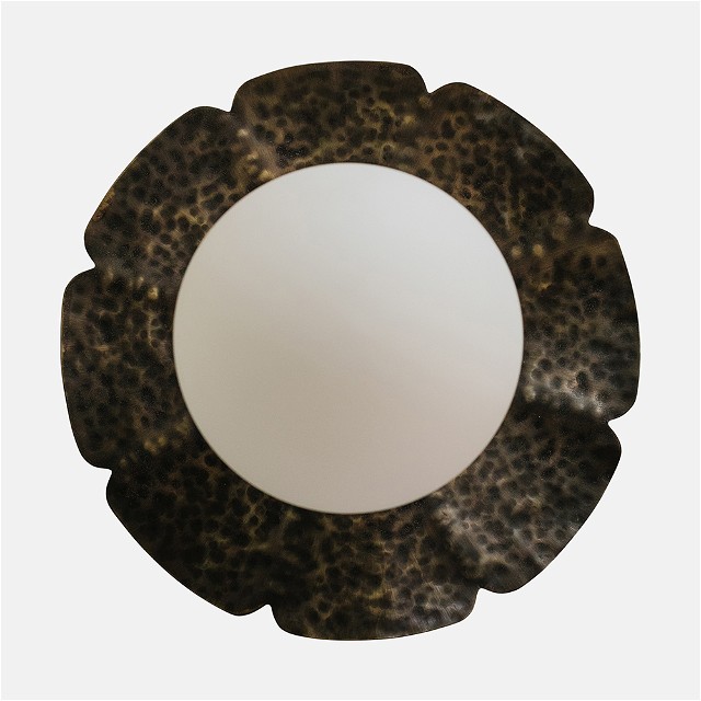 a round mirror sitting on top of a white wall