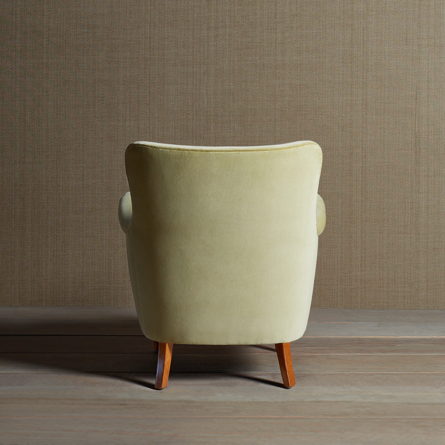 a chair with a wooden leg and a beige upholstered seat