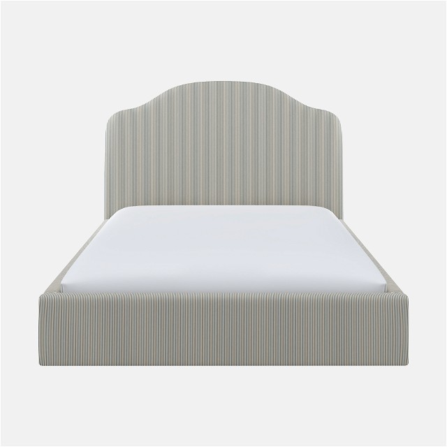 a white bed with a gray headboard and white sheets