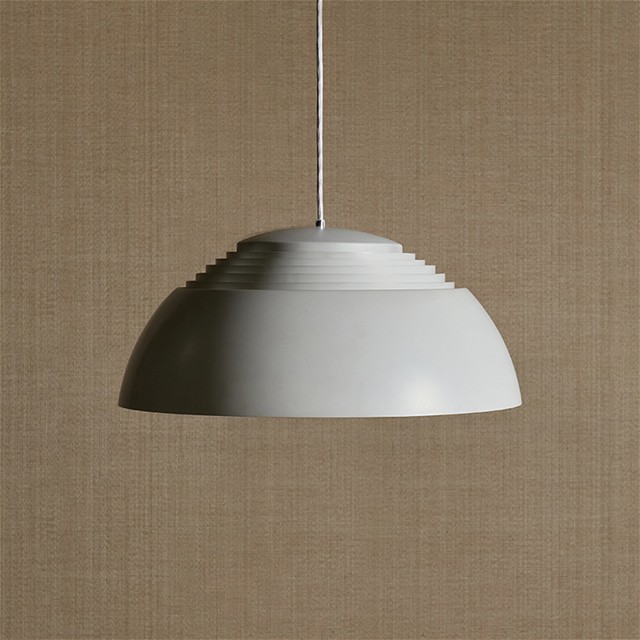 a white light hanging from a brown wall