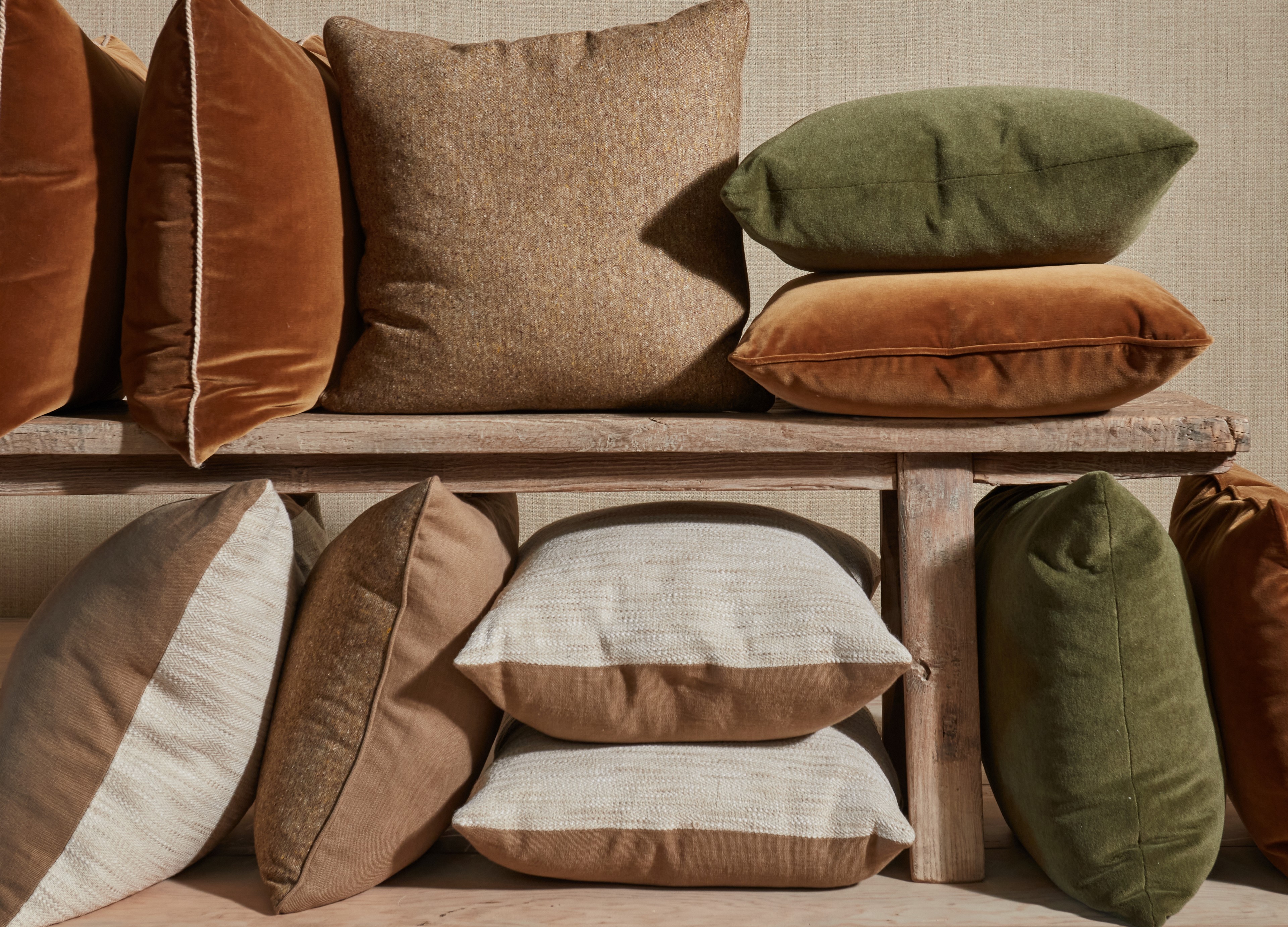a bunch of pillows sitting on top of a wooden shelf