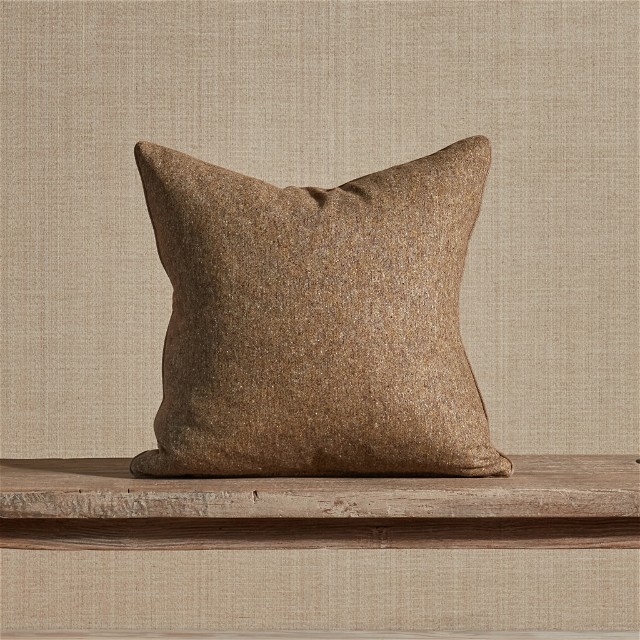 a brown pillow sitting on top of a wooden shelf
