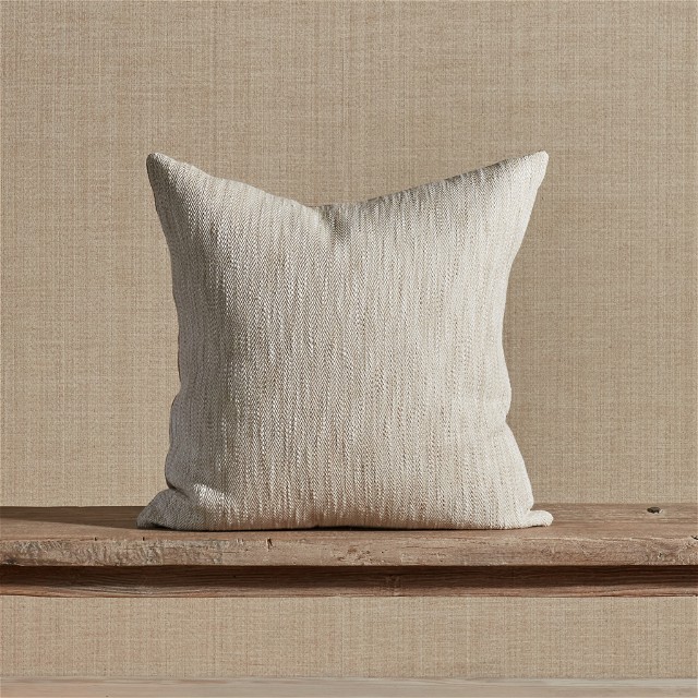 a white pillow sitting on top of a wooden shelf