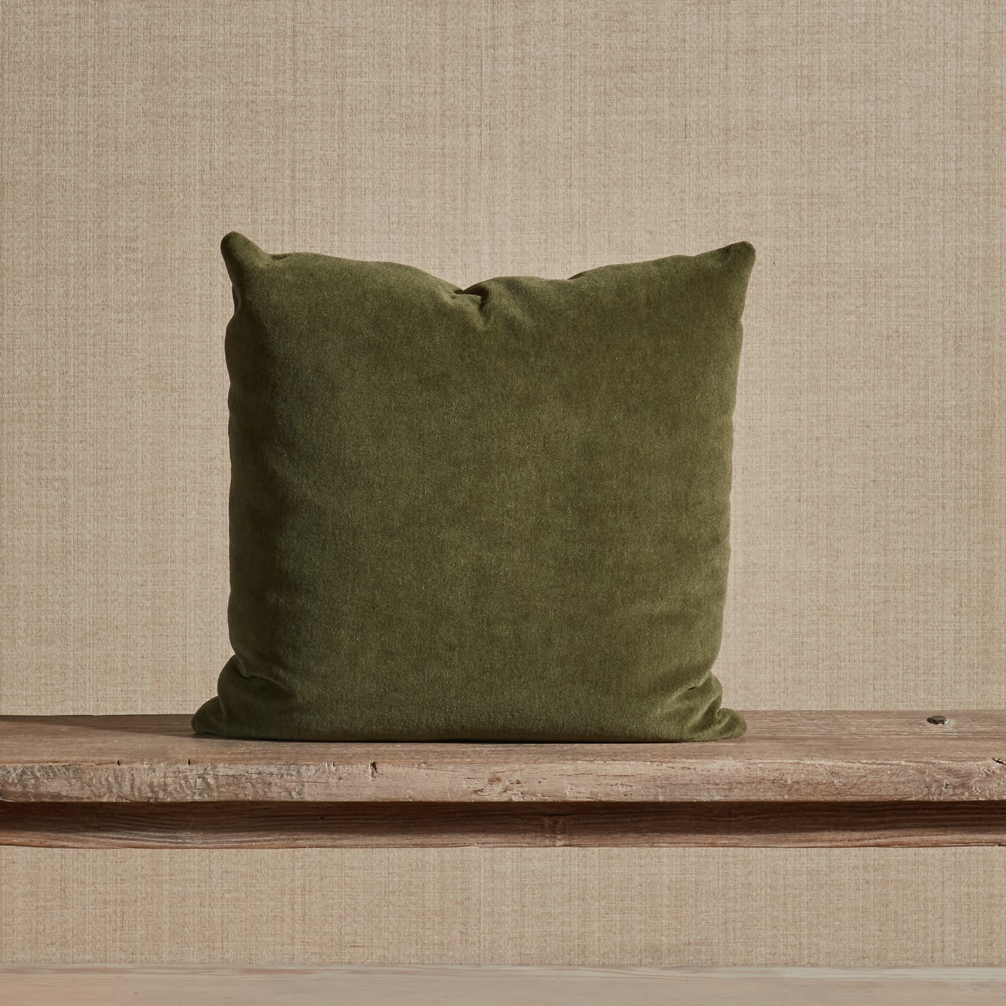 a green pillow sitting on top of a wooden shelf
