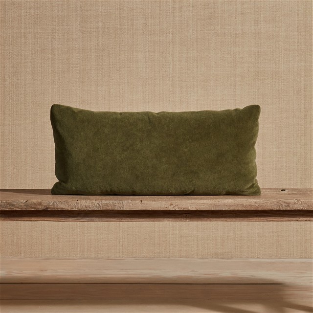a green pillow sitting on top of a wooden bench