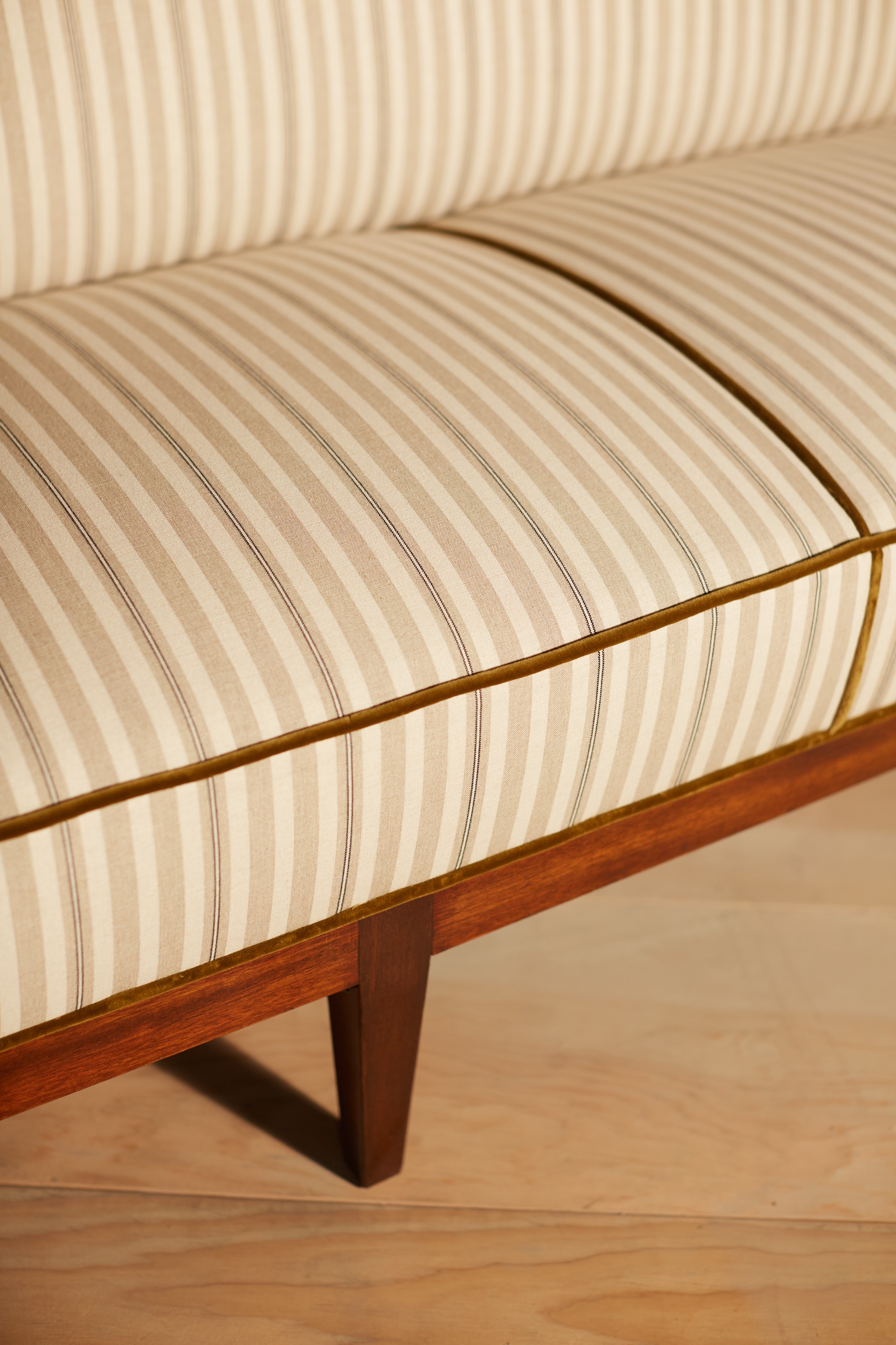 a close up of a striped bench on a wooden floor