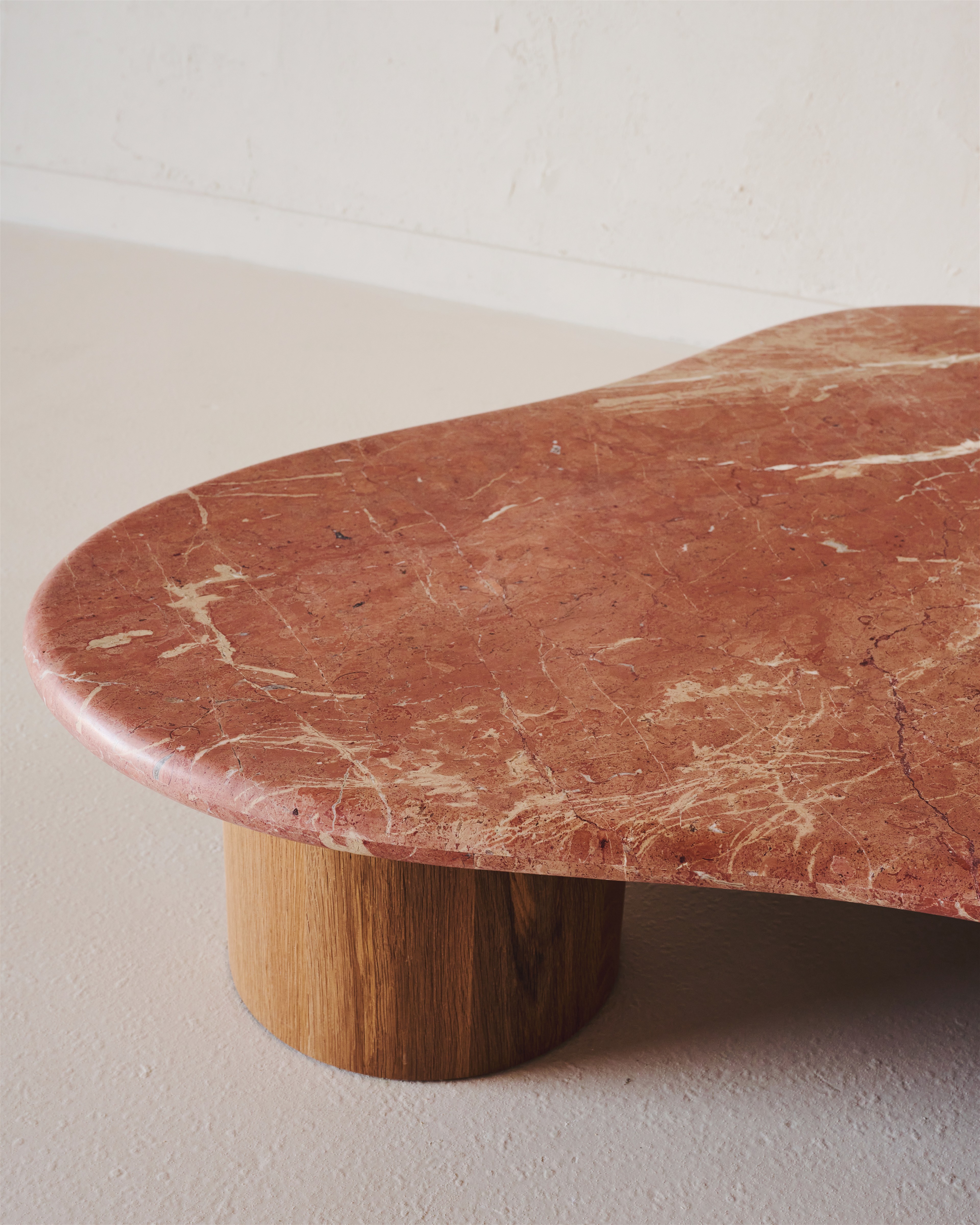 a red marble table with a wooden base