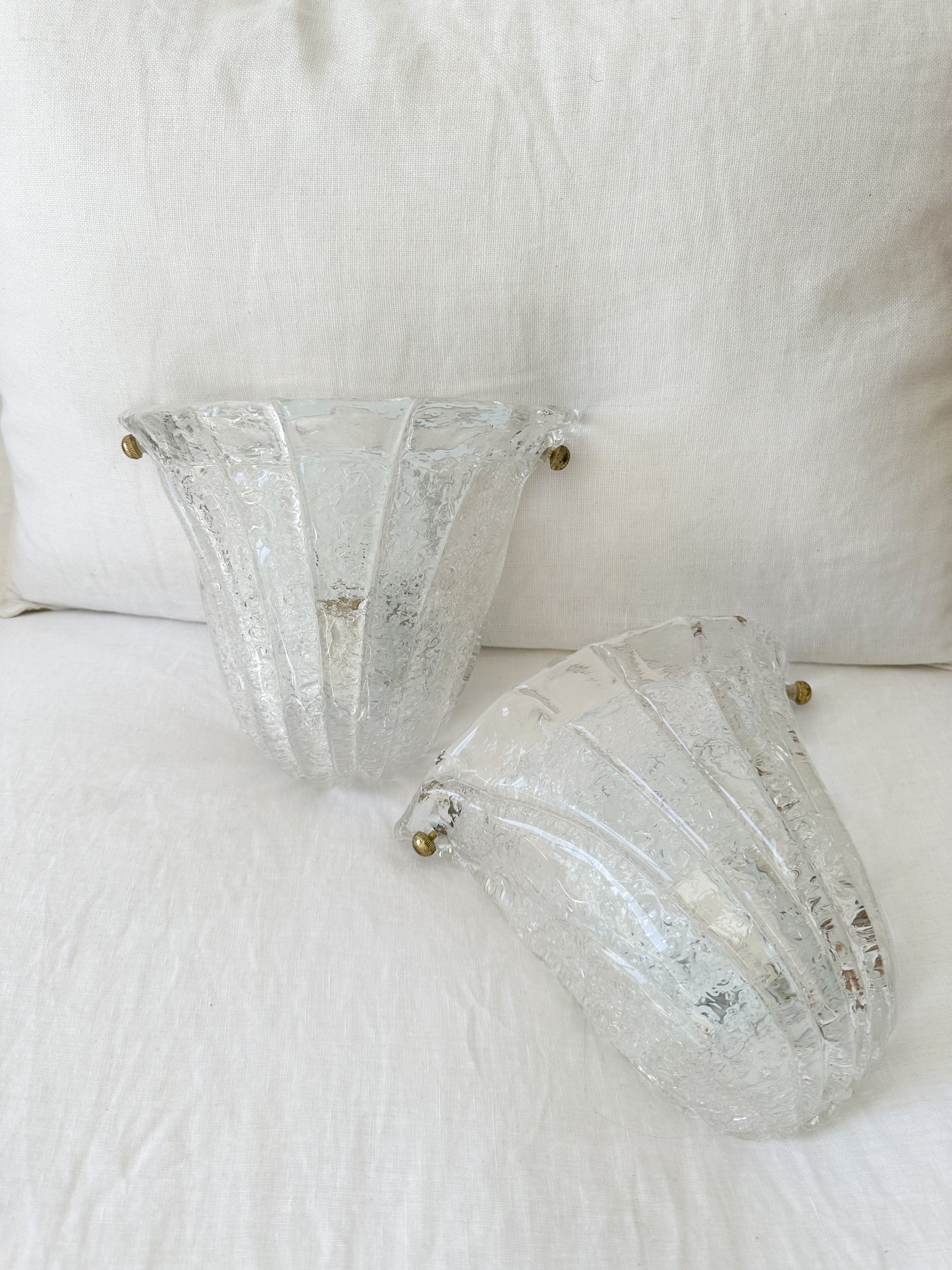 a couple of glass vases sitting on top of a bed