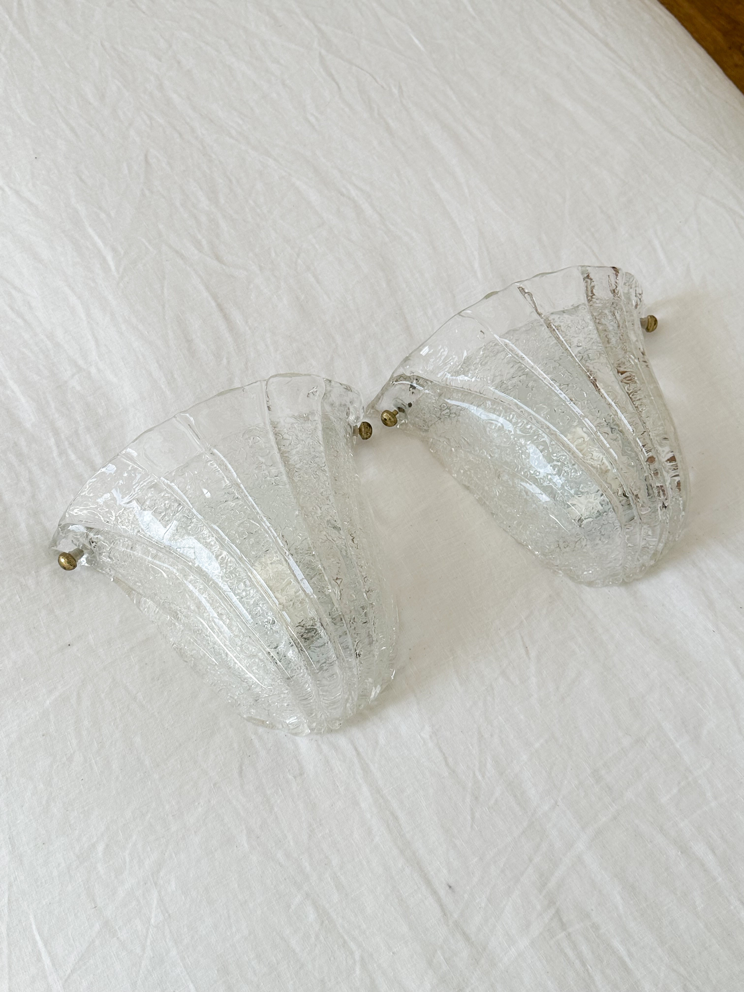 a pair of glass vases sitting on top of a white sheet