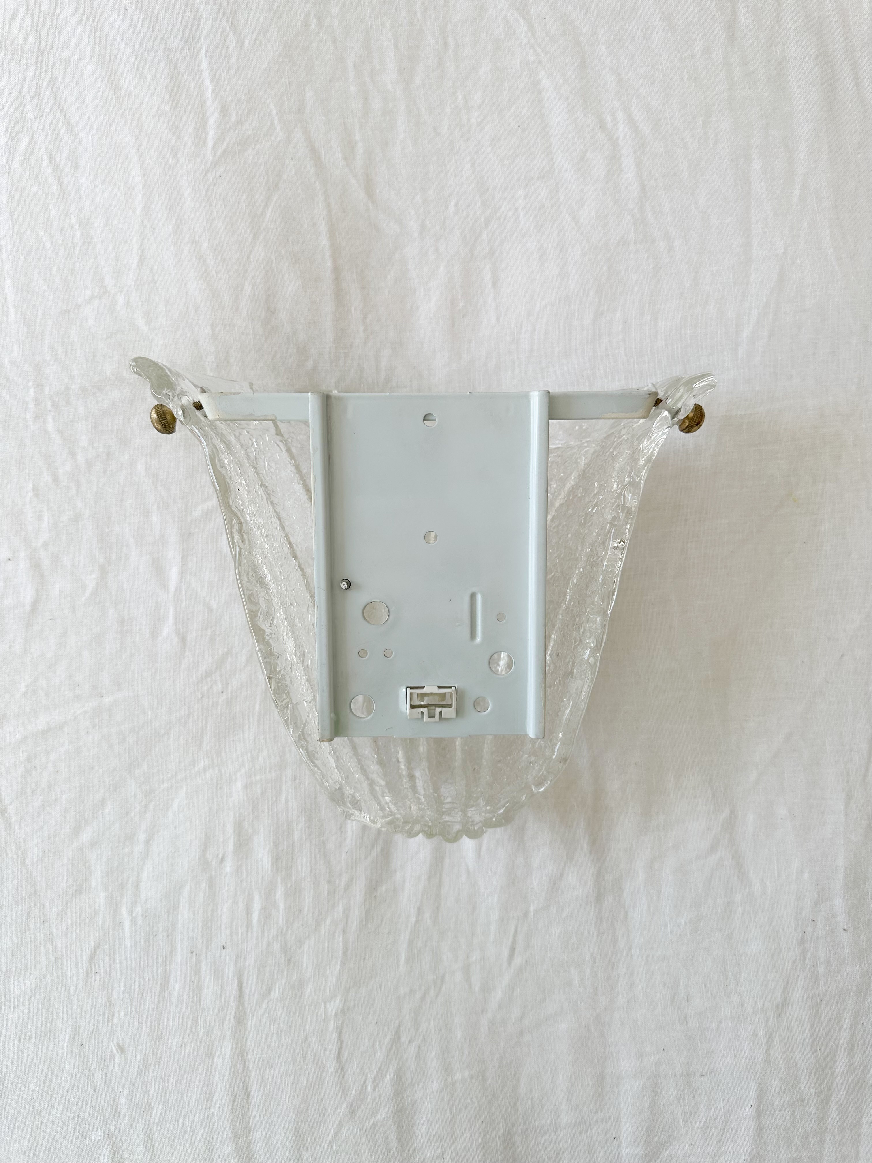 a white wall mounted electrical outlet with a white curtain