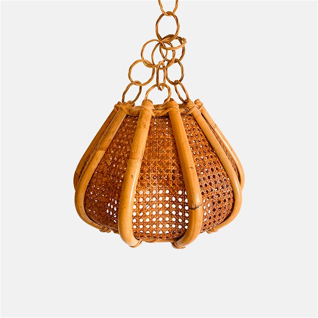 a brown rattan bag hanging from a chain
