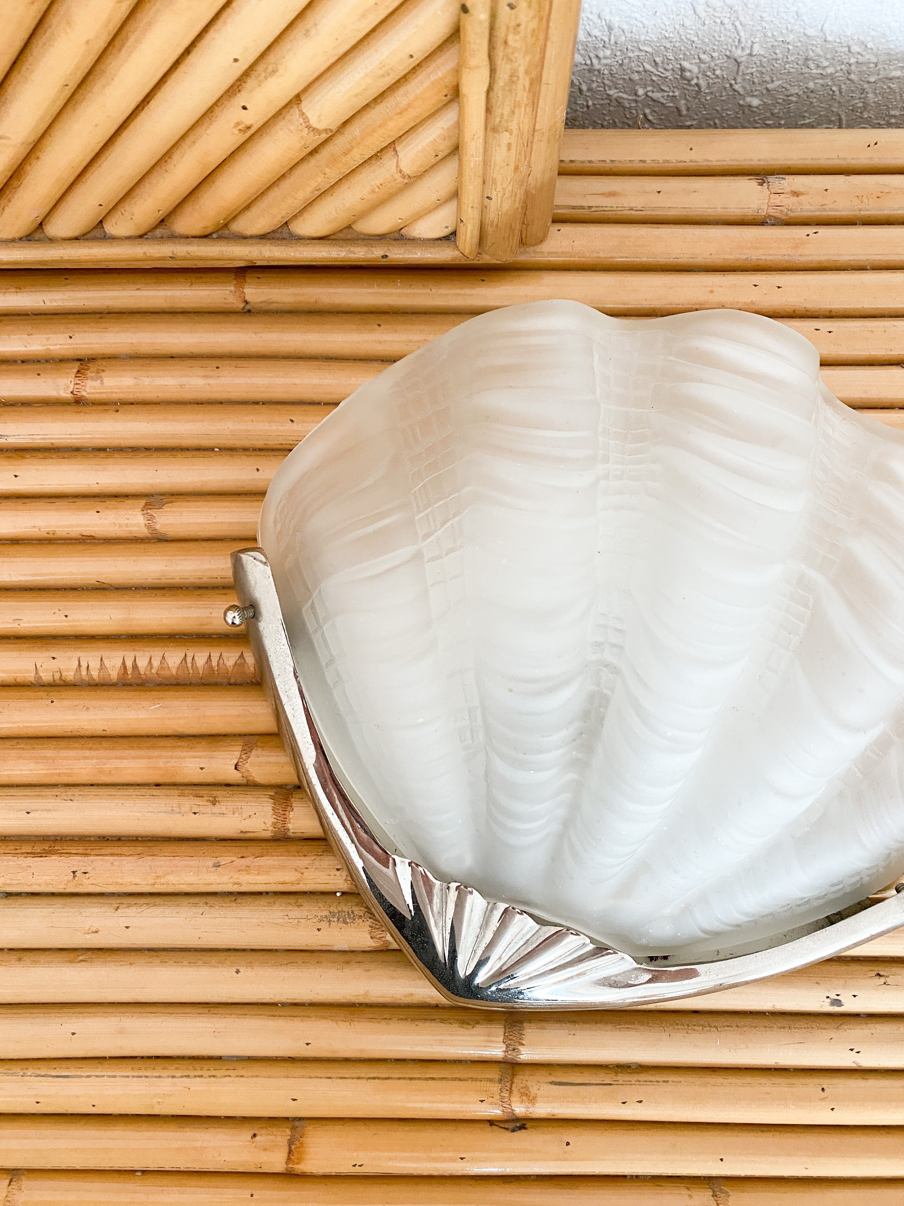 a large white shell sitting on top of a bamboo wall