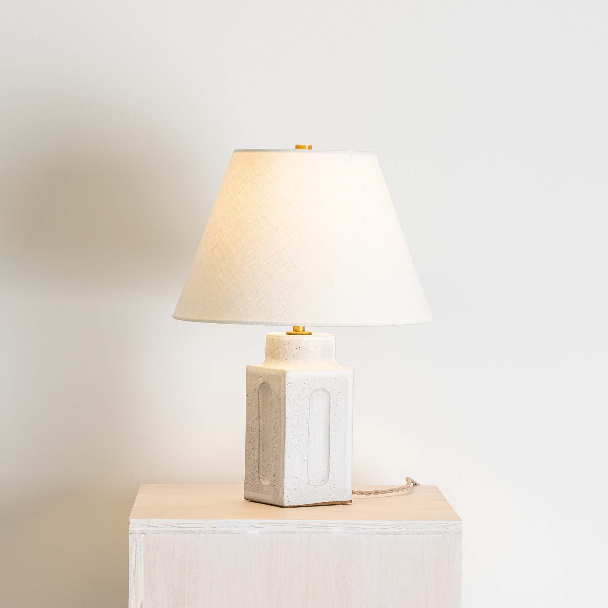 a white lamp sitting on top of a white table