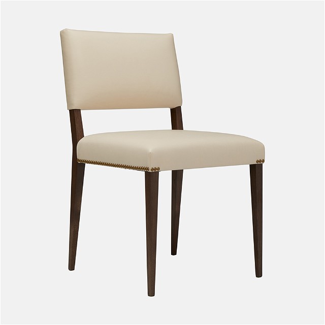 a white chair with wooden legs and a beige upholstered seat