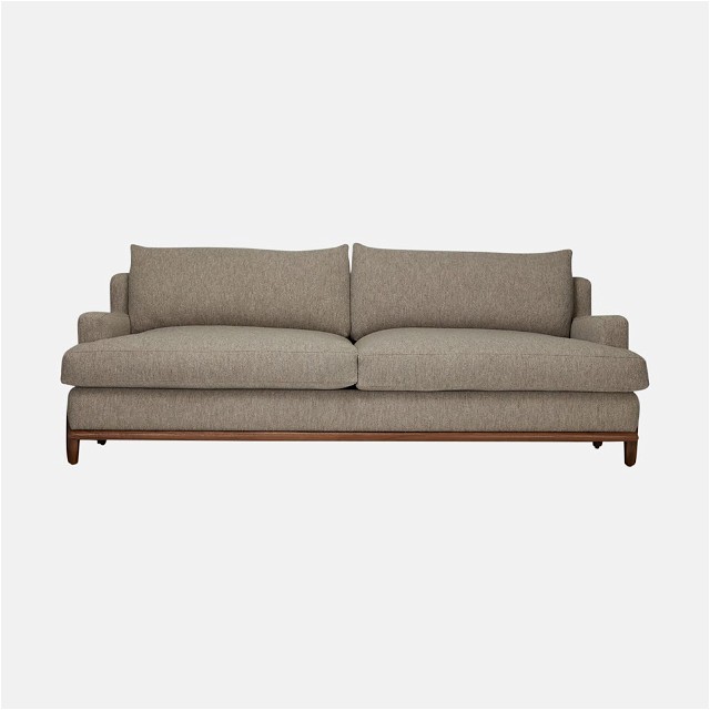 a beige couch with a wooden frame