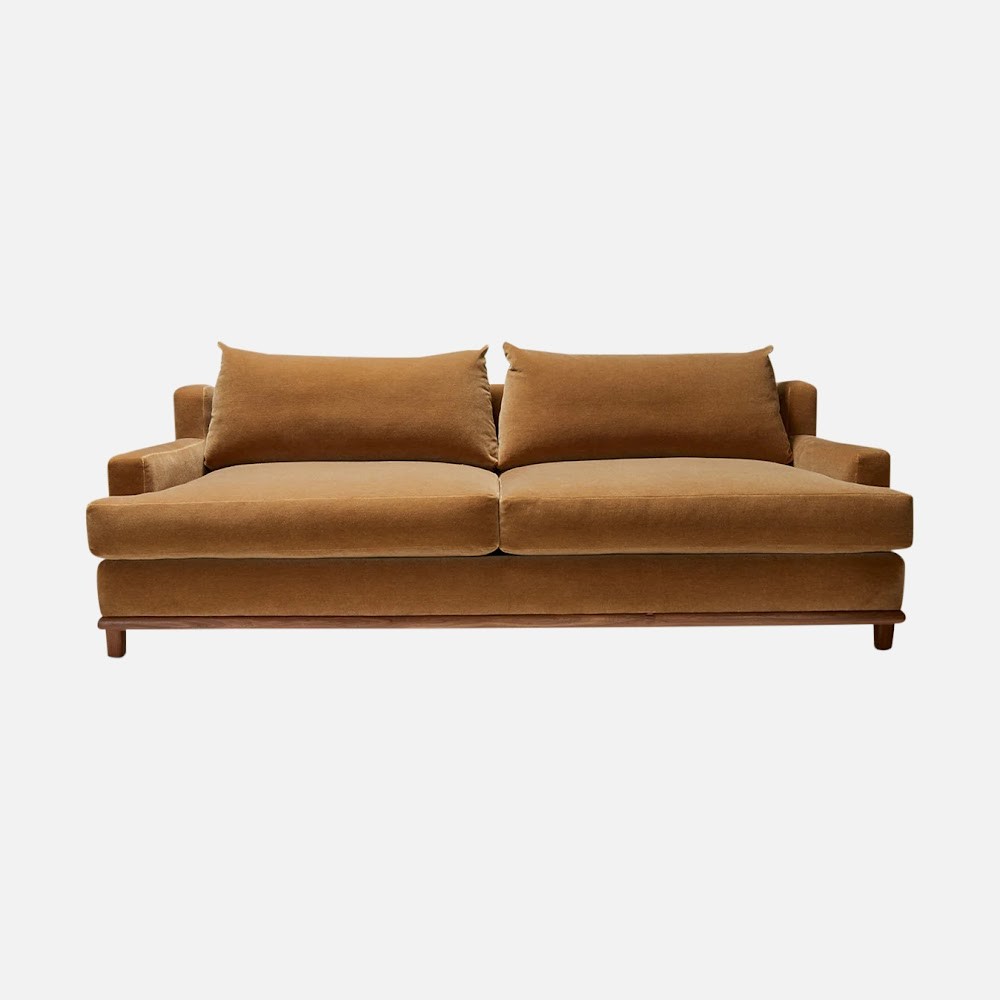 a brown couch with two pillows on top of it