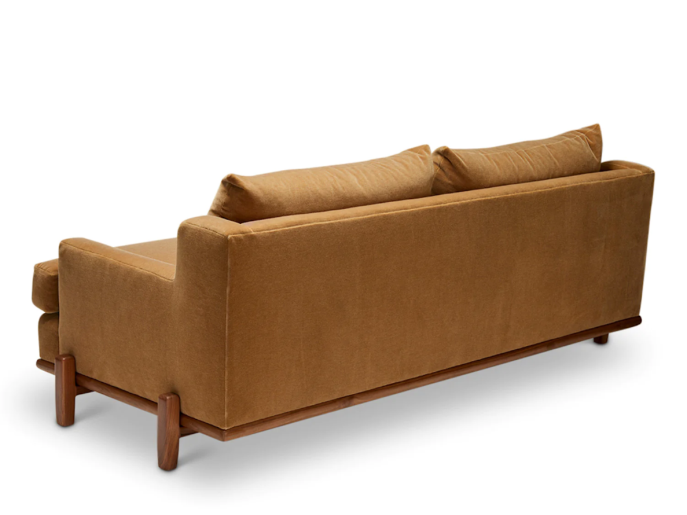 a brown couch with two pillows on top of it