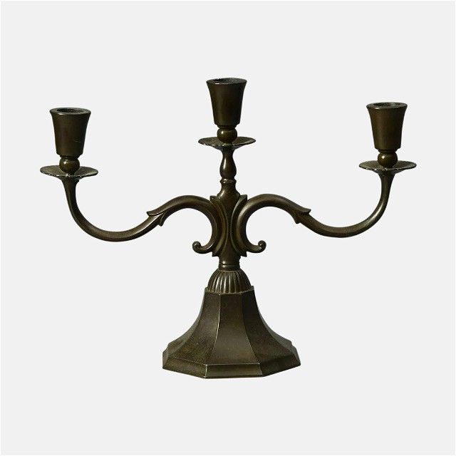 a metal candelabra with three candles on it