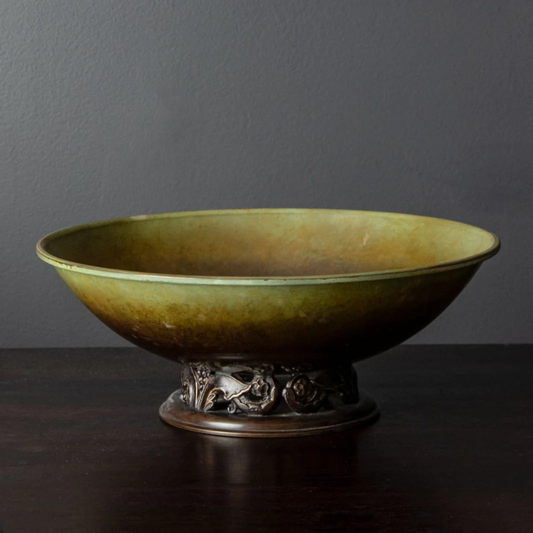 a green bowl sitting on top of a wooden table