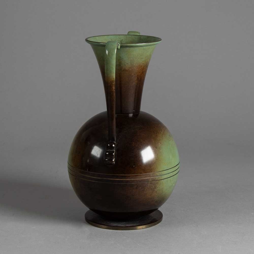 a brown and green vase sitting on top of a table