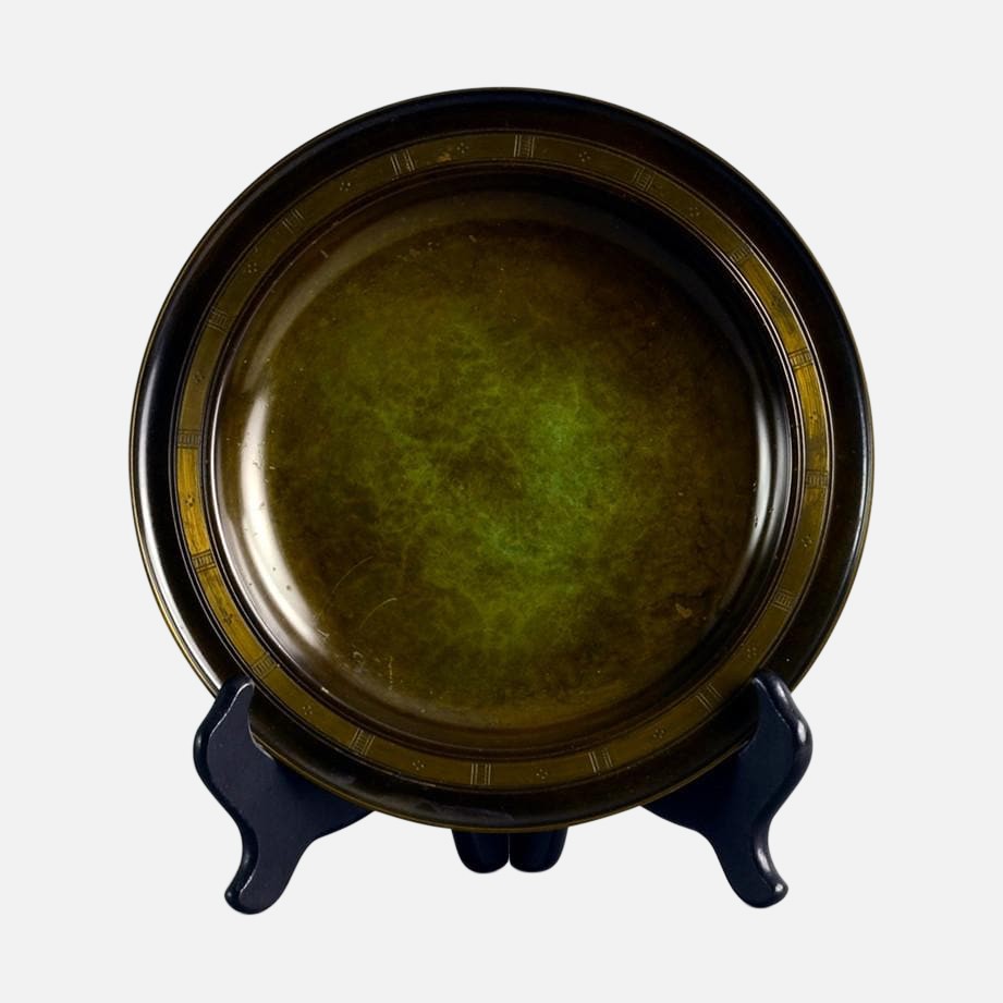 a green plate sitting on top of a black stand