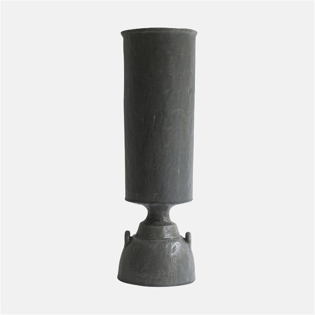 a gray vase sitting on top of a white surface