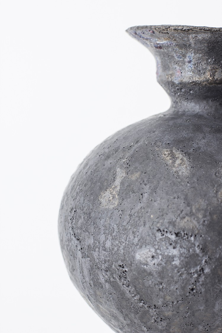 a large gray vase sitting on top of a table