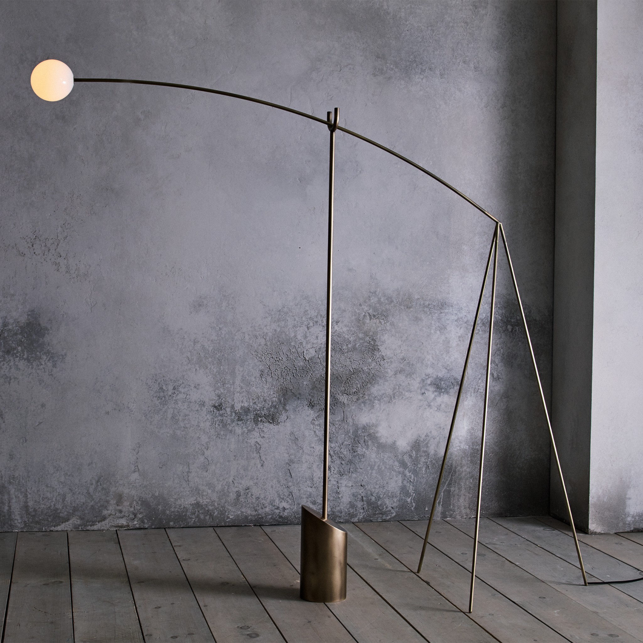 a floor lamp in a room with a concrete wall